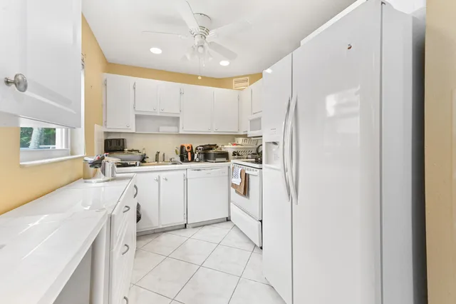 a kitchen with white cabinets and white appliances