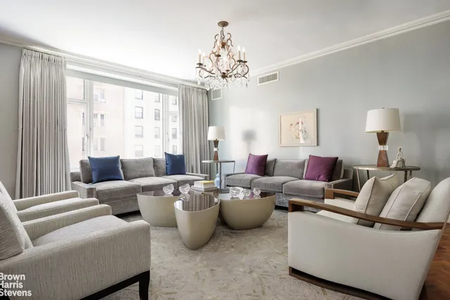 a living room with furniture and a chandelier
