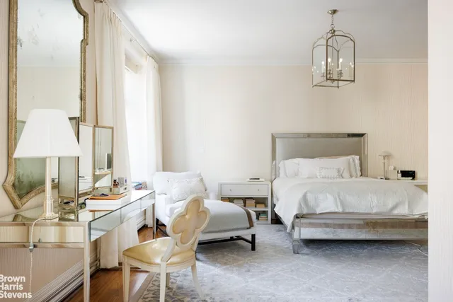 a spacious bedroom with a large bed and a chandelier