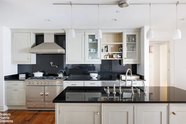 a kitchen with stainless steel appliances granite countertop a sink a stove top oven a counter space and cabinets