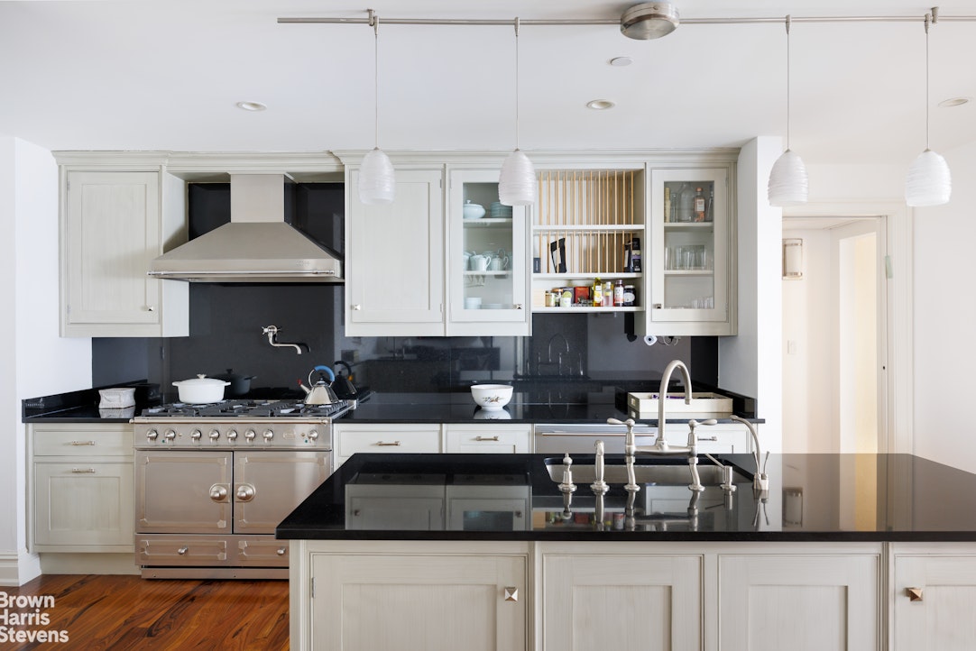 535 West End Avenue, Unit 8B Manhattan, NY 10024 - Photo 8 of 16 a kitchen with stainless steel appliances kitchen island granite countertop a sink a stove and a wooden floors