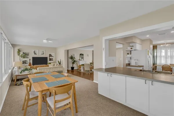 a living room with furniture a flat screen tv and kitchen view