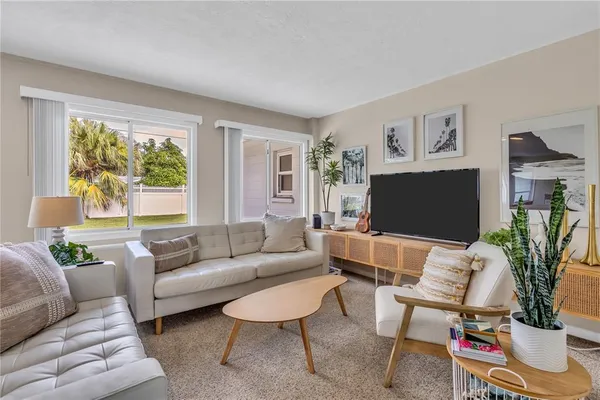 a living room with furniture a flat screen tv and a large window
