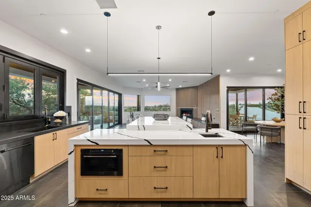 a room with stainless steel appliances kitchen island a large counter space a sink a stove and a window