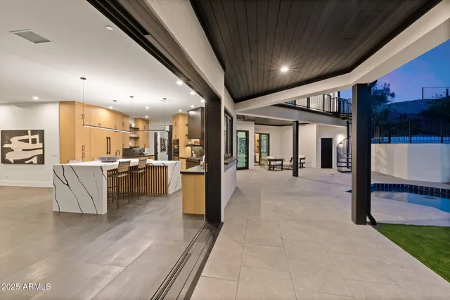 a patio with table and chairs and potted plants