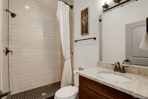 a bathroom with a granite countertop sink toilet and shower