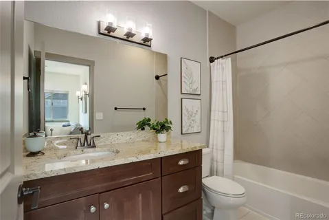 a bathroom with a granite countertop sink toilet and shower