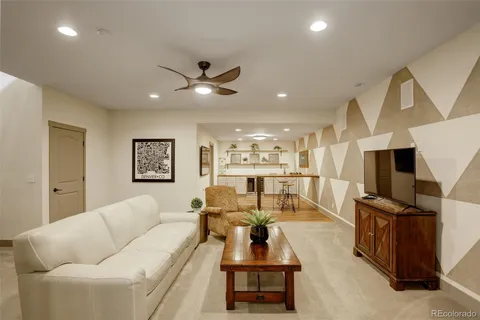 a living room with furniture kitchen view and a flat screen tv