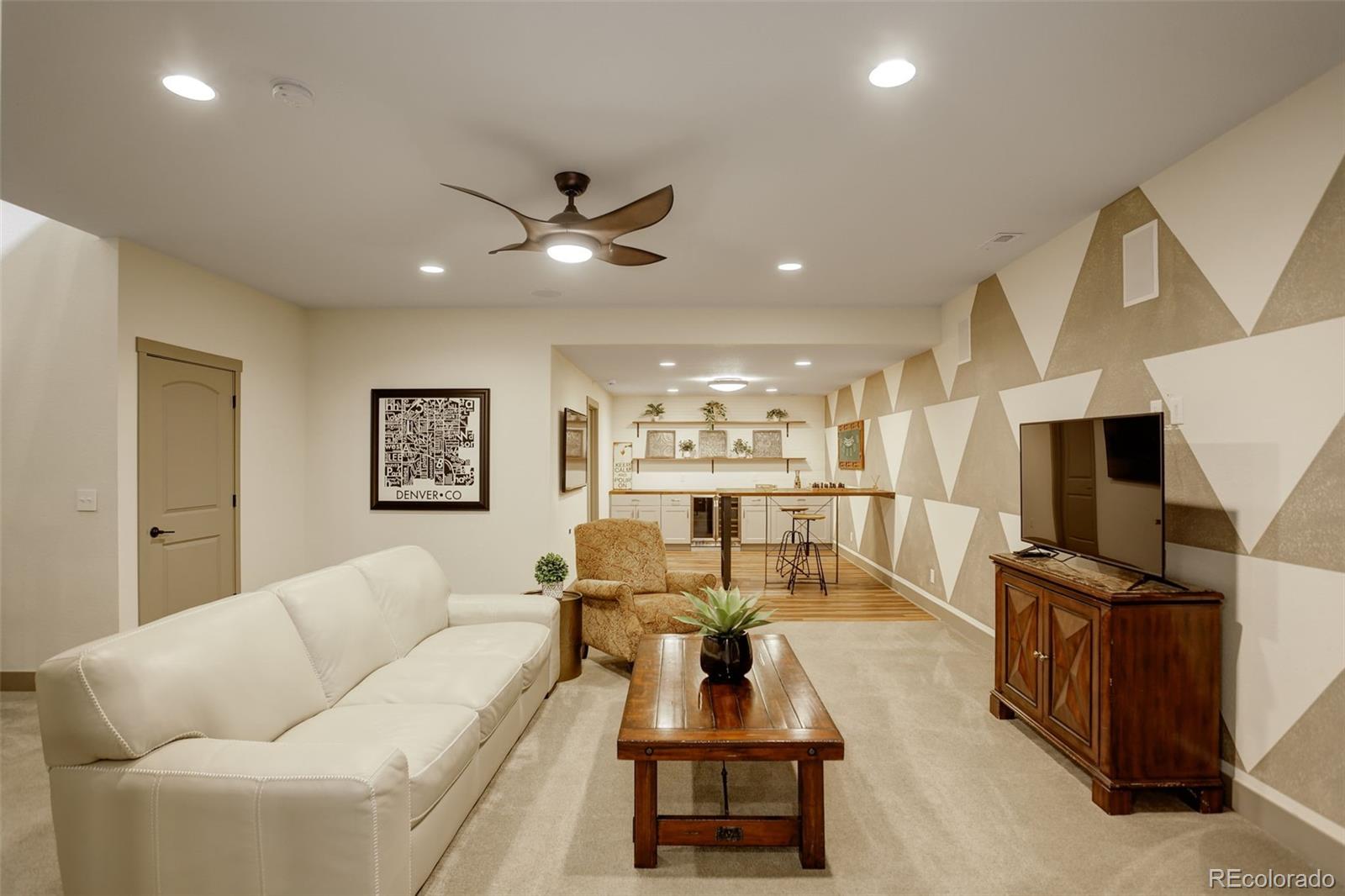 23451 East Rockinghorse Parkway Aurora, CO 80016 - Photo 25 of 36 a living room with furniture kitchen view and a flat screen tv