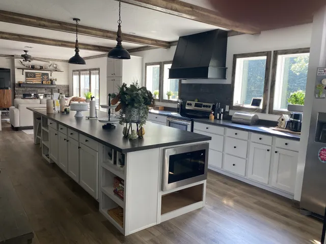 a kitchen with stainless steel appliances granite countertop a sink stove and cabinets