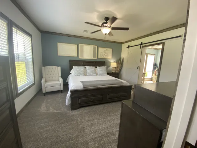 a bedroom with a bed furniture and a large window