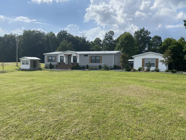 a view of a house with a yard and sitting area