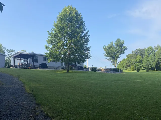 a view of a green field in front of a house