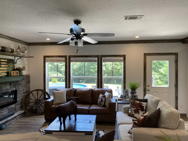 a living room with furniture ceiling fan and a window
