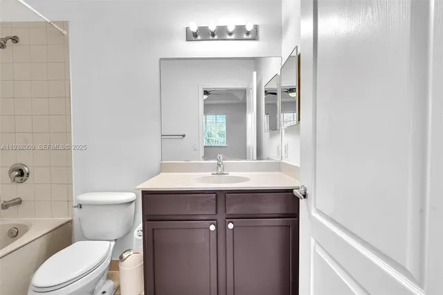a bathroom with a granite countertop sink a toilet and a mirror