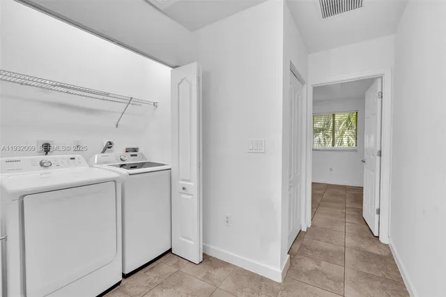 a utility room with cabinets washer and dryer