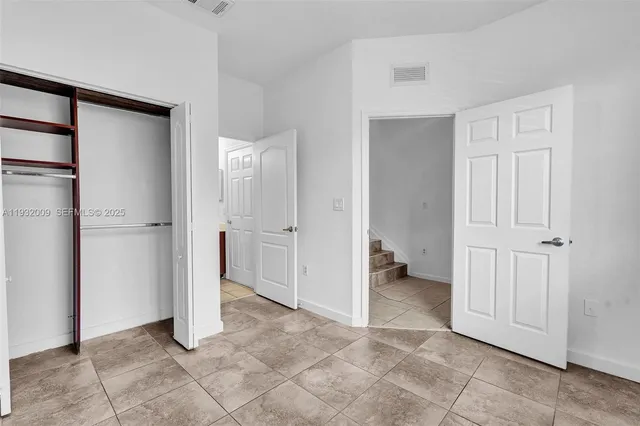 an empty room with closet and a bathroom view