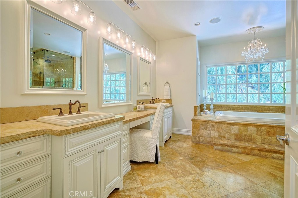 5839 Jed Smith Road Hidden Hills, CA 91302 - Photo 20 of 46 a bathroom with a granite countertop sink mirror and a bathtub