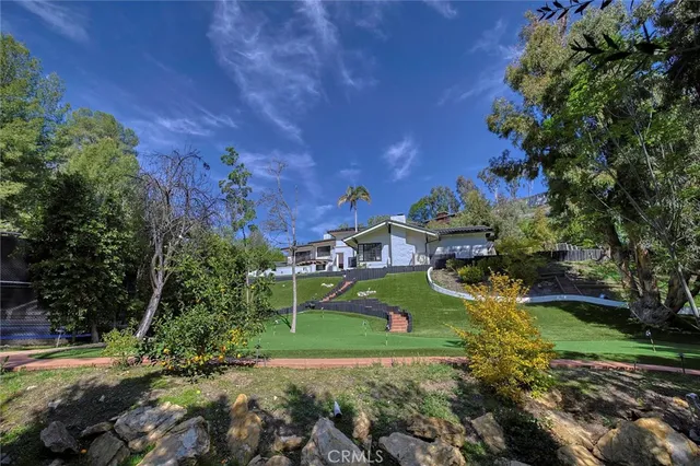 a view of a swimming pool with lawn chairs under an umbrella