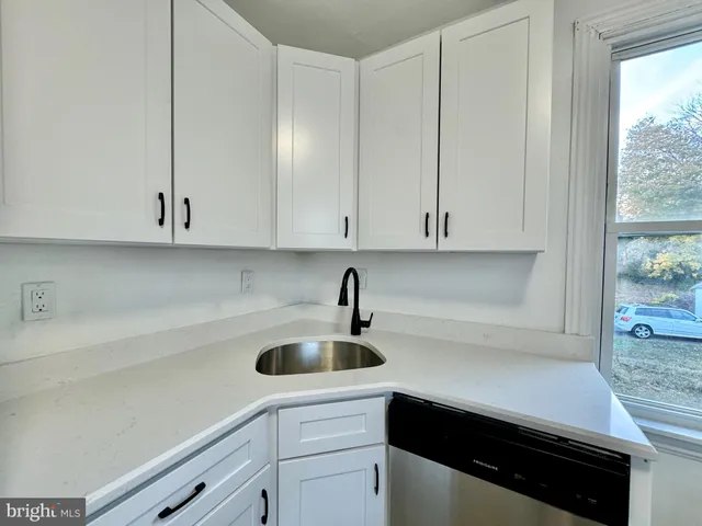 a bathroom with a tub a sink and a large mirror
