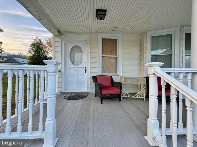 a backyard of a house with wooden floor and outdoor seating