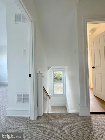 a view of staircase with lots of frames on wall and stairs