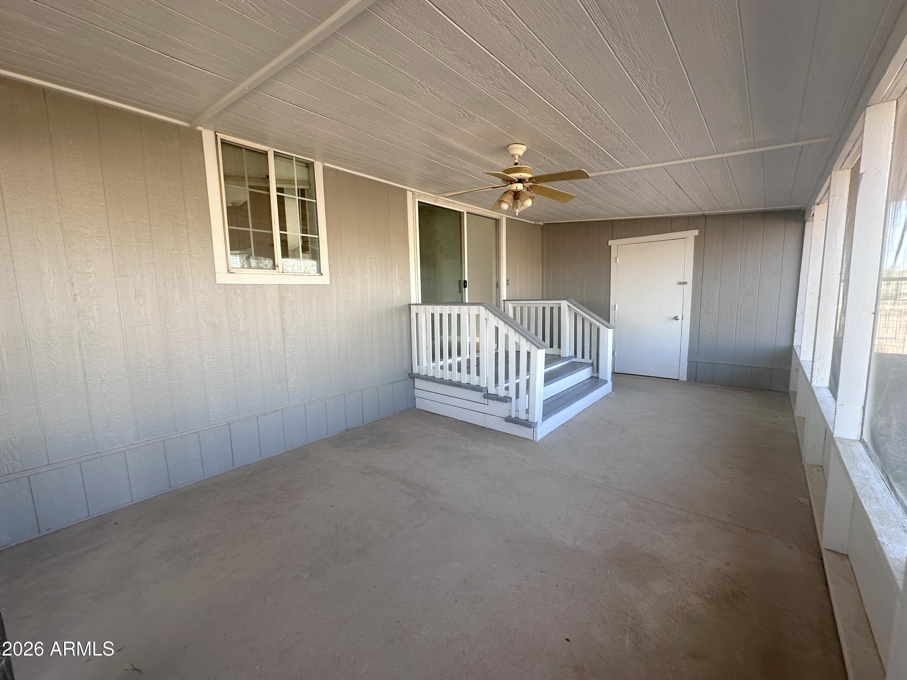 7736 West Alsdorf Road Arizona City, AZ 85193 - Photo 32 of 45 an empty room with windows and a ceiling fan