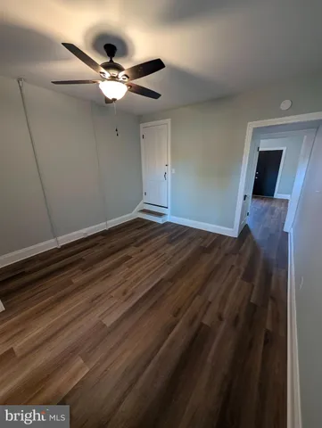 a view of a livingroom with a ceiling fan and wooden floor