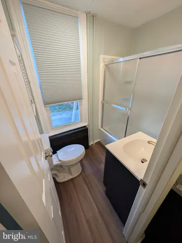 a bathroom with a sink a toilet a mirror and shower