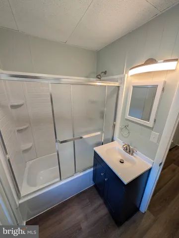 a bathroom with a sink mirror and tub