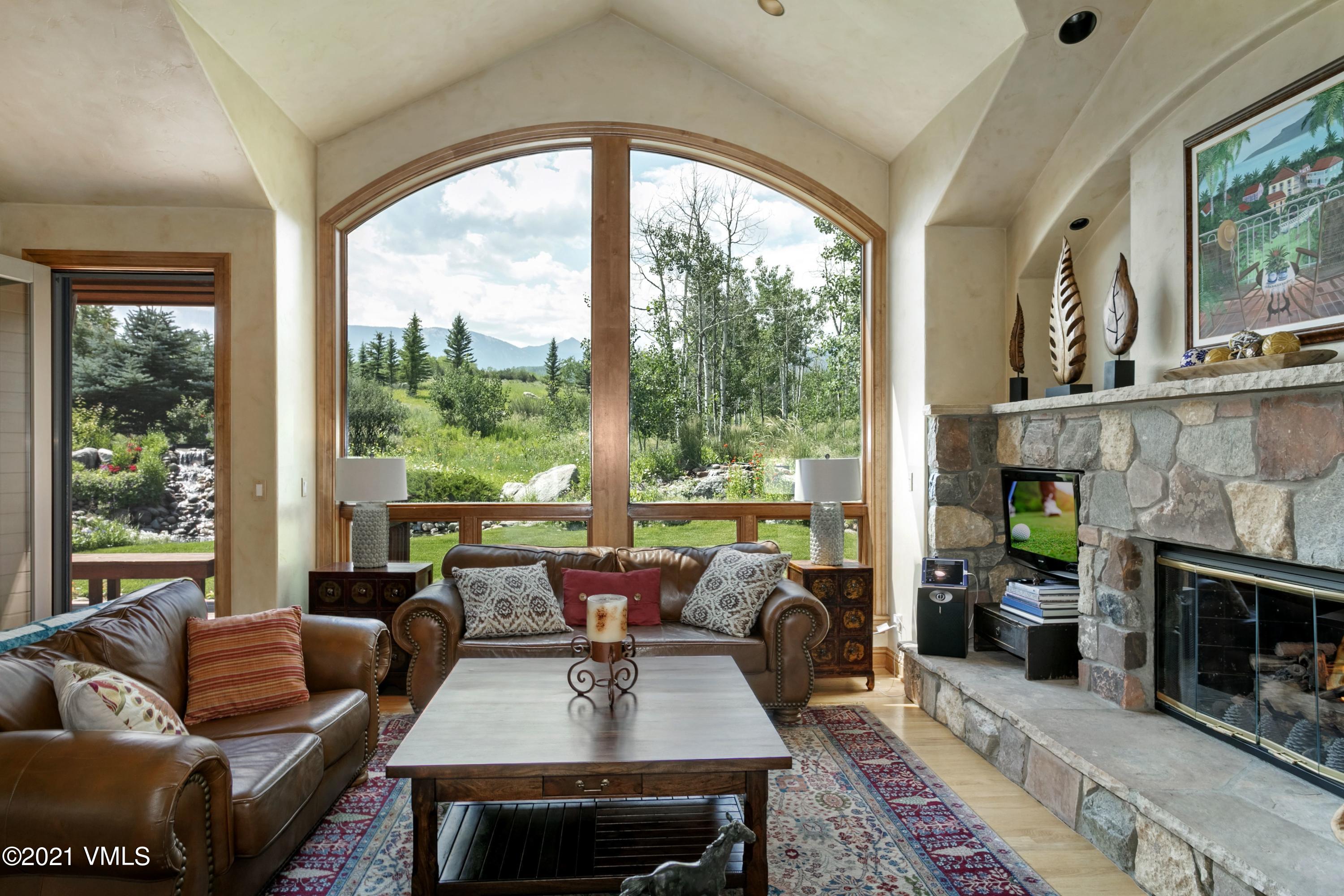 a living room with furniture a large window and a fireplace
