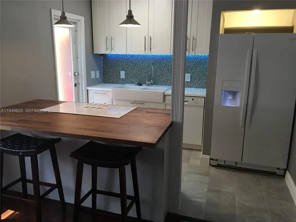 a view of a kitchen area with furniture and wooden floor