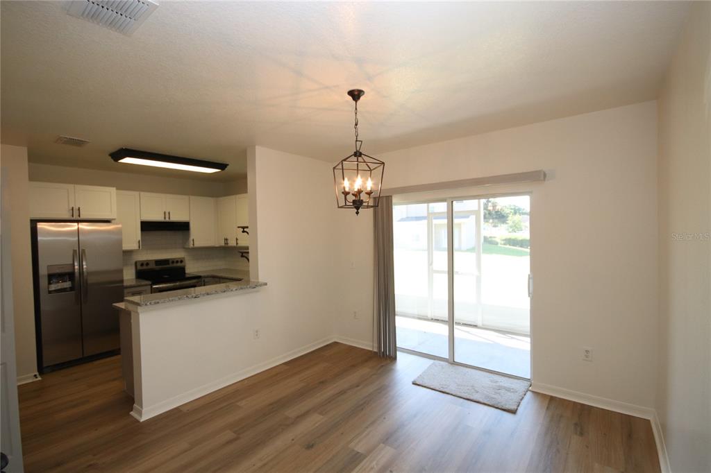 1575 Blue Magnolia Road Brandon, FL 33510 - Photo 7 of 22 a kitchen with wooden floors and stainless steel appliances