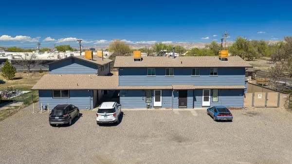 an aerial view of residential houses with outdoor space and parking