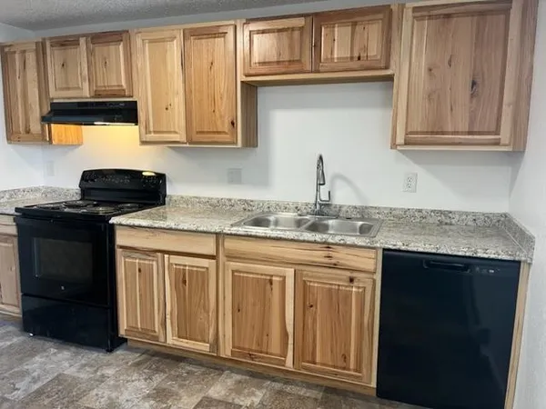 a kitchen with a sink a stove and cabinets