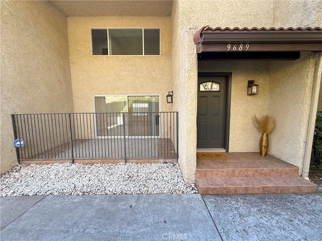 a side view of a house with a wooden fence