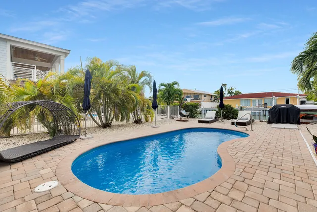 a view of a patio with a table and chairs under an umbrella