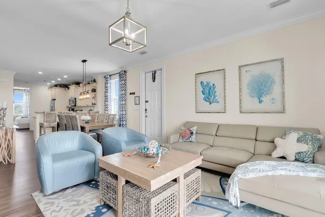 a view of a dining room and livingroom with furniture wooden floor a chandelier