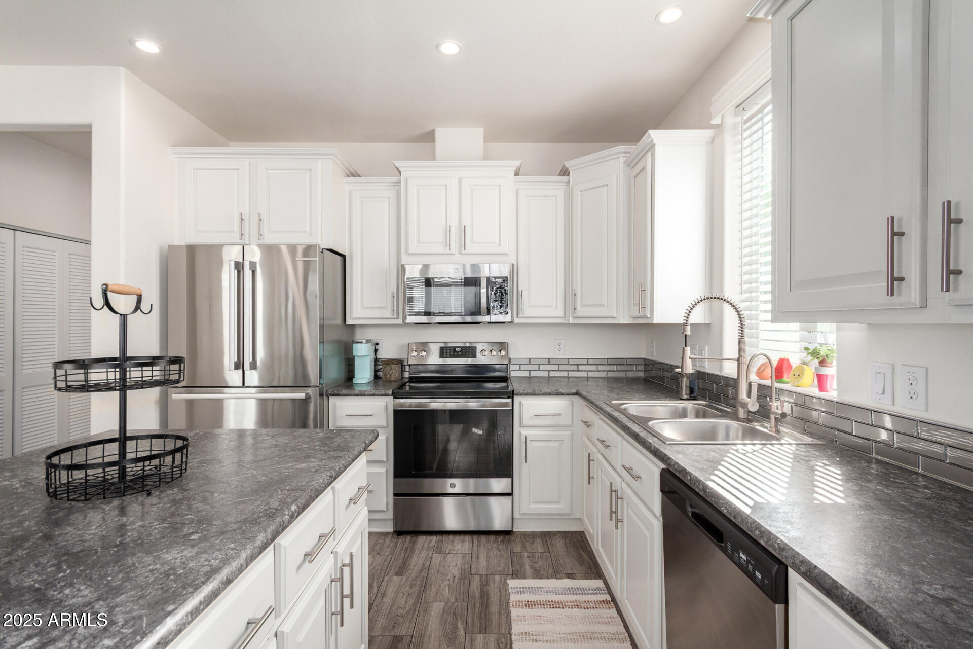 2206 South Ellsworth Road, Unit 103B Mesa, AZ 85209 - Photo 15 of 27 a kitchen with stainless steel appliances granite countertop a sink a stove and a refrigerator