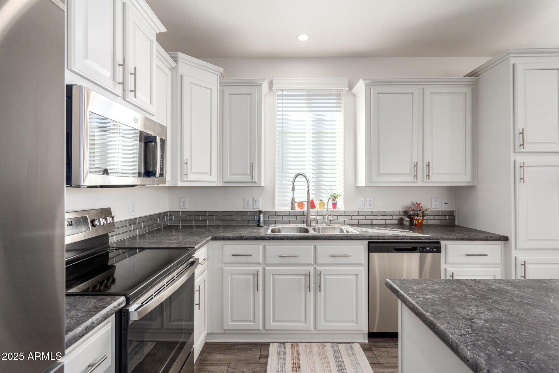 2206 South Ellsworth Road, Unit 103B Mesa, AZ 85209 - Photo 16 of 27 a kitchen with granite countertop a sink stove and cabinets