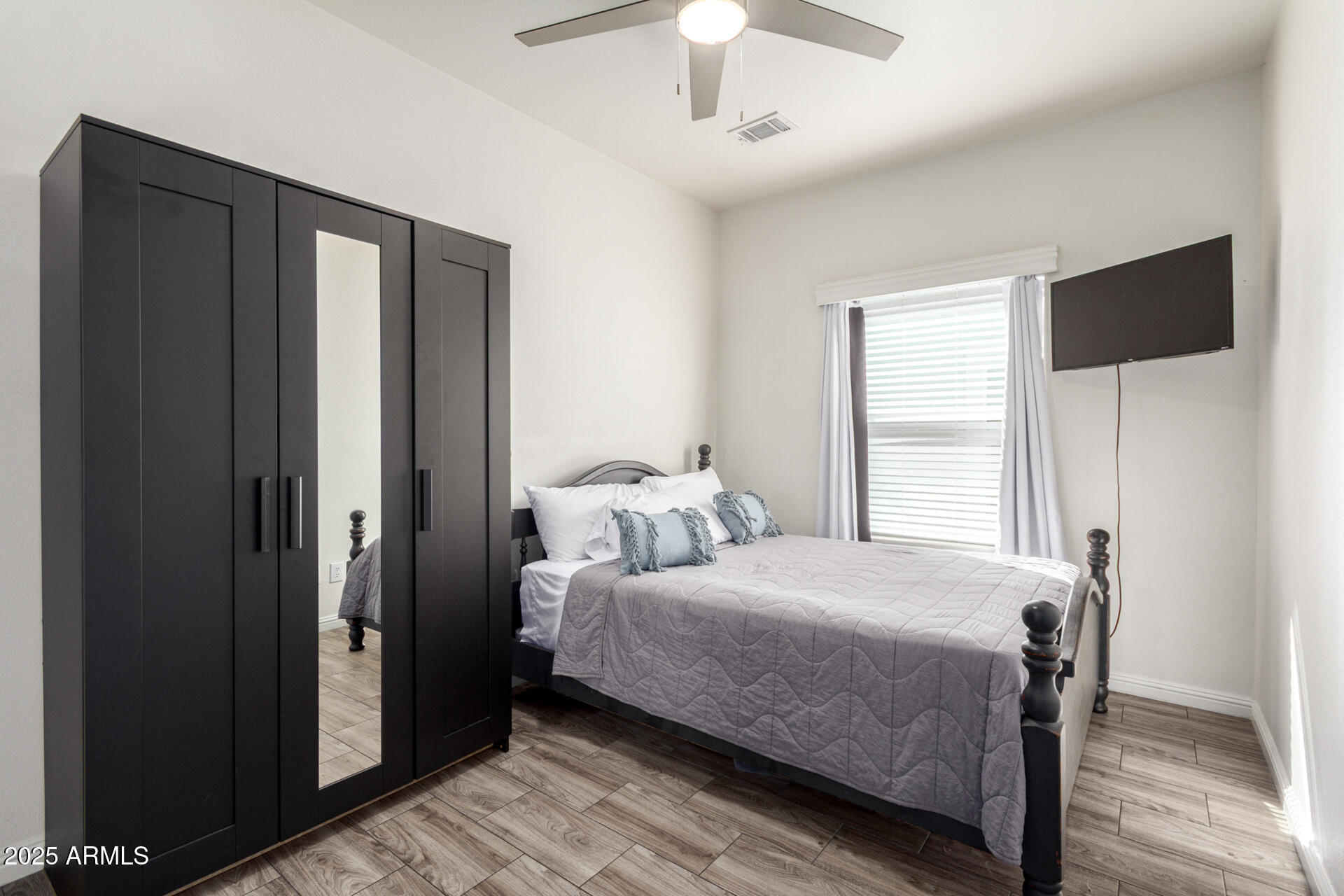 2206 South Ellsworth Road, Unit 103B Mesa, AZ 85209 - Photo 22 of 27 a bedroom with a bed and a chandelier