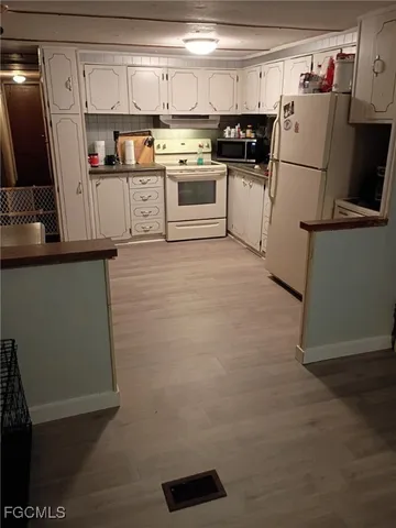 a kitchen with granite countertop a refrigerator stove and sink