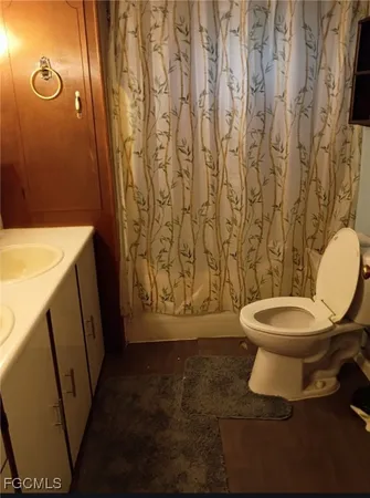 a bathroom with a toilet and a shower curtain
