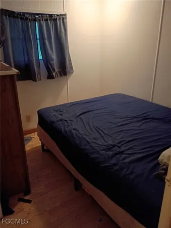 a bed sitting in a bedroom next to a wooden cabinet