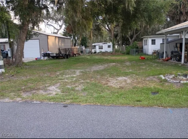 a view of a house with a yard and large trees
