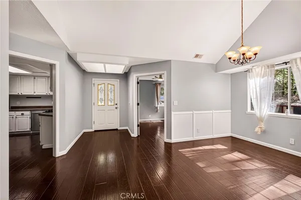 a kitchen with cabinets stainless steel appliances and wooden floor