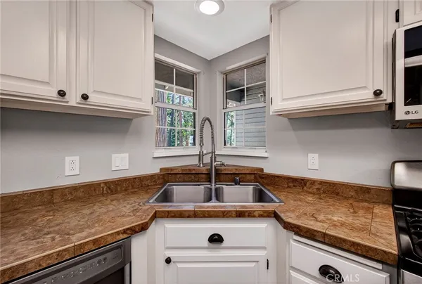 a kitchen with granite countertop a stove a sink and a microwave