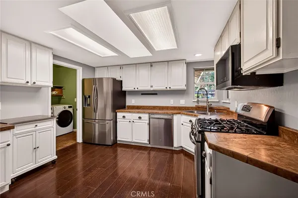 a view of a kitchen with wooden floor and cabinets
