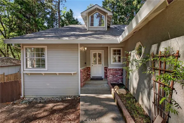 a view of a house with a tree and wooden fence