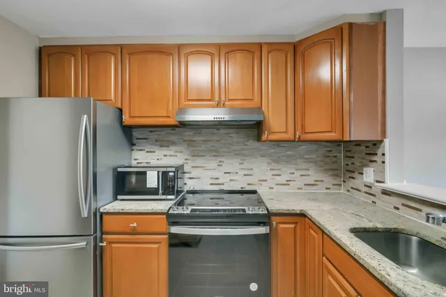 a kitchen with a sink a refrigerator and cabinets